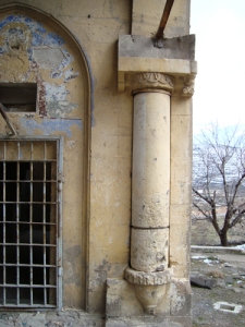 De oude ingang (met erboven een schildering) met draaibare kolom